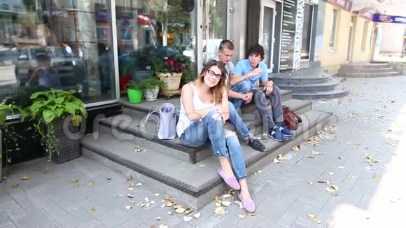年轻的三个朋友坐在街上说话用视频的预览图