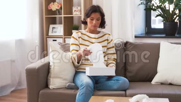 生病的女人在家里用纸巾吹鼻子视频的预览图
