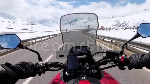 骑摩托车的人骑在瑞士阿尔卑斯山附近美丽的雪山公路上视频的预览图