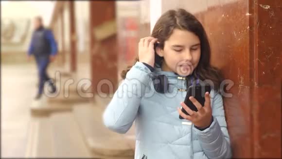 少女在地下生活方式地铁乘坐地铁等待火车的到来手持智能手机视频的预览图