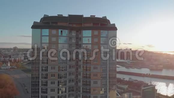 城市景观河岸上的住宅综合体日落时直升机的空中镜头视频的预览图