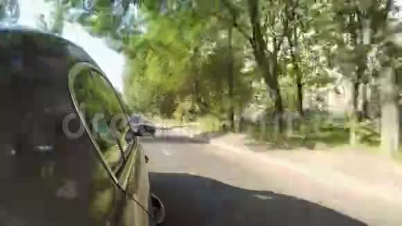 在阳光明媚的夏日汽车沿着城市街道行驶车身侧视视频的预览图