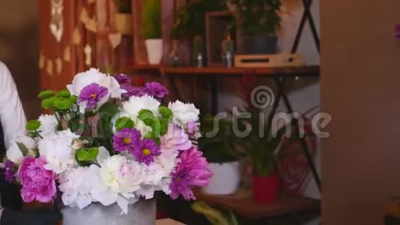 花店花店布置现代花束年轻英俊的花店在花店做花束视频的预览图