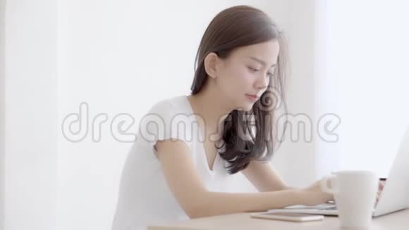 美丽的年轻自由职业亚洲女性微笑着在办公桌办公室工作带着专业的笔记本电脑视频的预览图