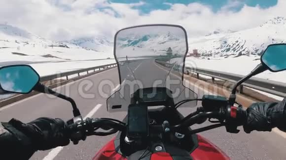 摩托车手骑在瑞士阿尔卑斯山附近美丽的风景雪山公路上瑞士视频的预览图