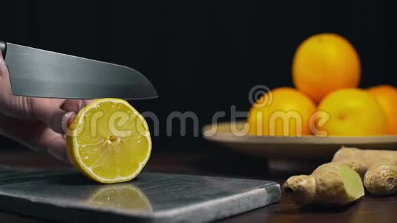 柠檬是用锋利的刀在岩石板上切片新鲜的橙色切片水果和维生素素食制作视频的预览图