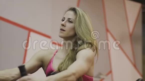 非常漂亮的女教练在健身俱乐部的健身机上训练视频的预览图