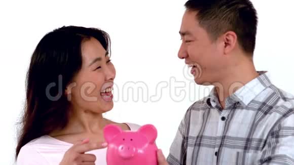 一对亚洲夫妇抱着储蓄罐接吻视频的预览图