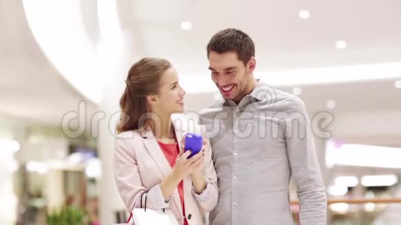 有智能手机的快乐情侣在商场自拍视频的预览图