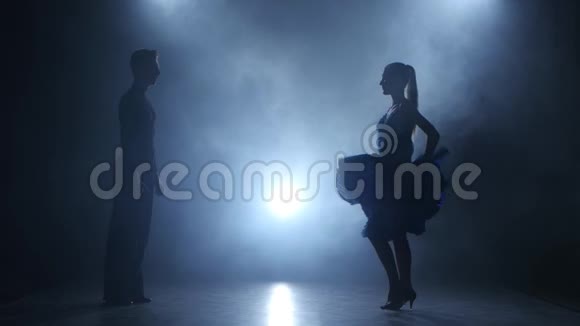 专业的萨尔萨舞者在烟雾弥漫的工作室里摆姿势剪影视频的预览图