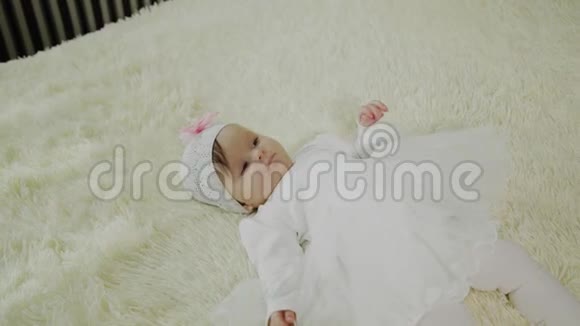 美丽的小女孩躺在白色的床上视频的预览图