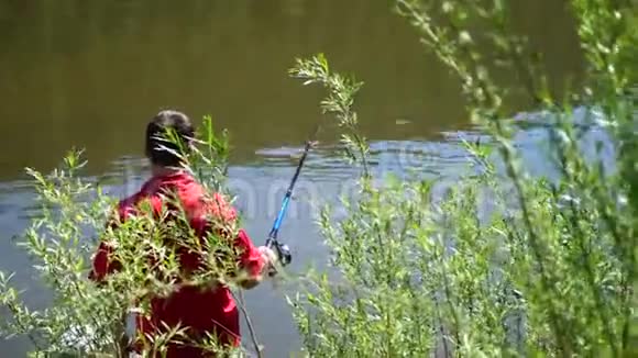 两个小孩和一个年轻的父亲在河岸钓鱼美丽的夏日风景户外娱乐活动视频的预览图