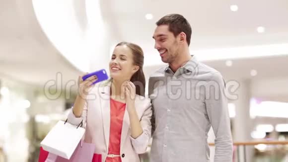 有智能手机的快乐情侣在商场自拍视频的预览图