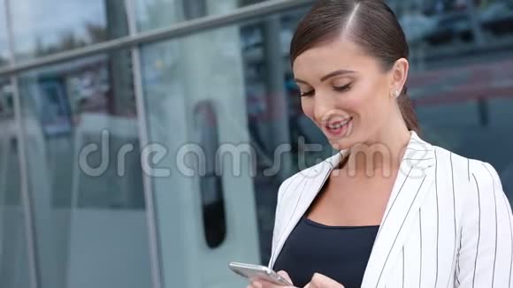 美丽的商务女性在办公室门口打电话视频的预览图