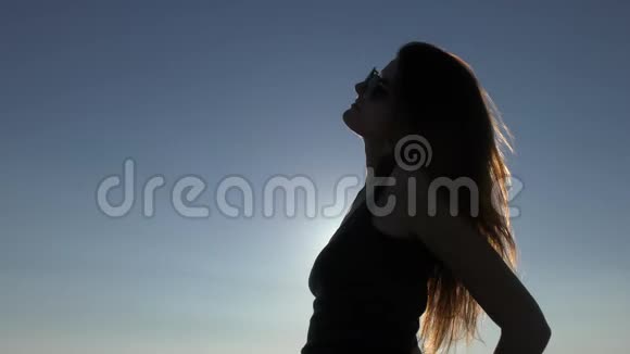 日落时分海滩上年轻迷人的女人视频的预览图