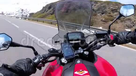 在瑞士阿尔卑斯山附近的美丽风景雪山公路上骑摩托车视频的预览图