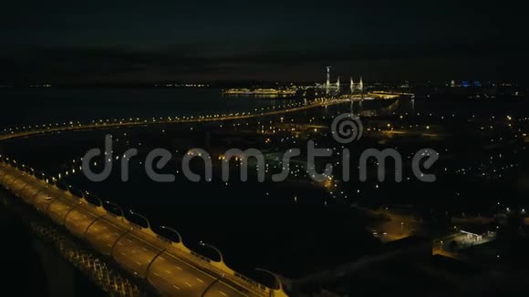 以现代城市建筑为背景在夜桥上驾驶的空中观景车视频的预览图