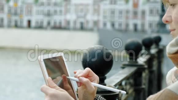 女人在户外使用平板电脑春天视频的预览图