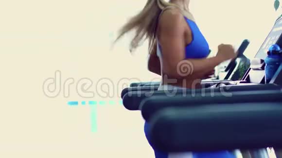 年轻的健身妇女在健身房做有氧运动在跑步机上跑步视频的预览图