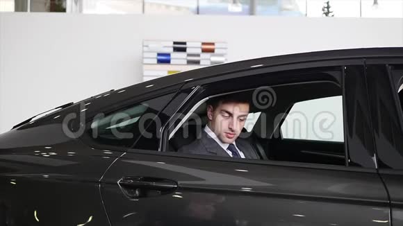 一名男子检查车辆内部汽车生意汽车销售技术和人的概念快乐的男性与汽车视频的预览图