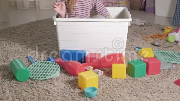 可爱的笑着的小男孩学龄前的金发女郎在一个白色的盒子里玩五颜六色的玩具坐在地板上视频的预览图
