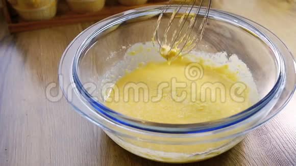 用电动搅拌器将面粉与已经打好的鸡蛋和糖混合慢动作视频的预览图