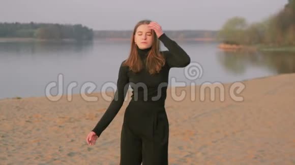 穿着黑色衣服的年轻漂亮女孩在河边跳舞剪影视频的预览图