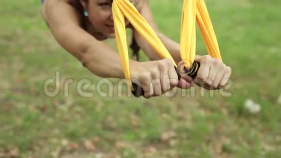反重力瑜伽在公园里用吊床做瑜伽运动的女人视频的预览图