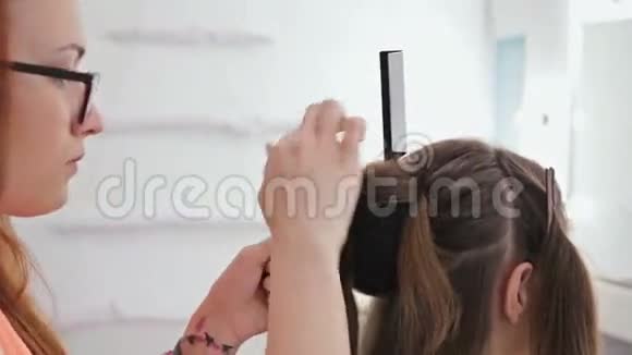 近距离射击为年轻美女做发型的专业理发师视频的预览图