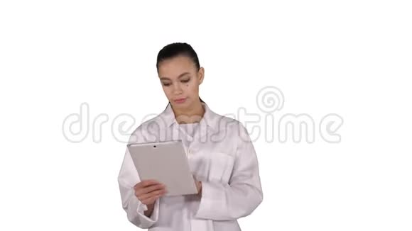 医生在白色背景下行走时使用平板电脑视频的预览图