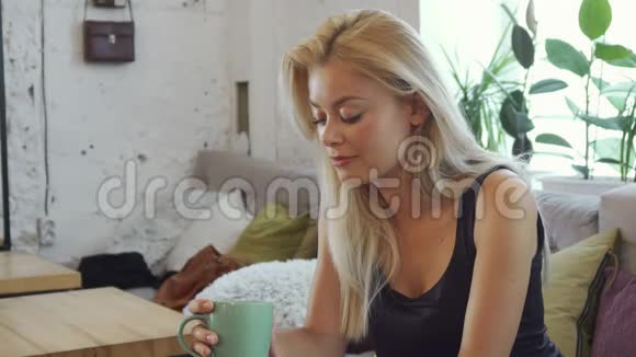 金发女郎正在喝咖啡视频的预览图