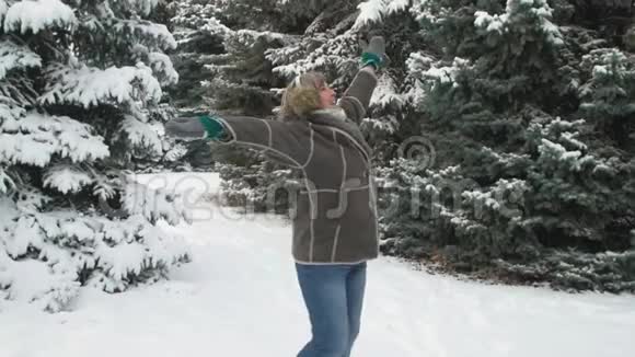 女人在冬天的森林里摆姿势美丽的风景和雪杉树视频的预览图