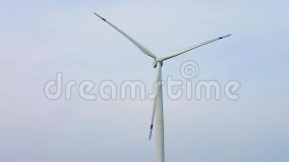 在蓝天背景上旋转风车螺旋桨的叶片风力发电纯绿色能源视频的预览图