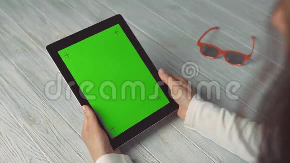 女人拿着绿色屏幕的平板电脑视频的预览图