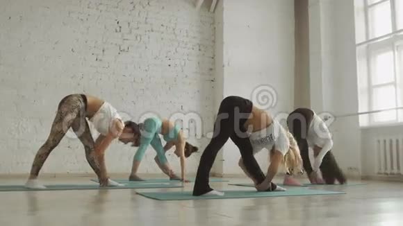 年轻女孩做瑜伽一群人在伸展课堂上健康的生活方式视频的预览图