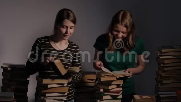 两个女孩母亲和她十几岁的女儿或者两个姐妹正在看书玩书4KUHD视频的预览图