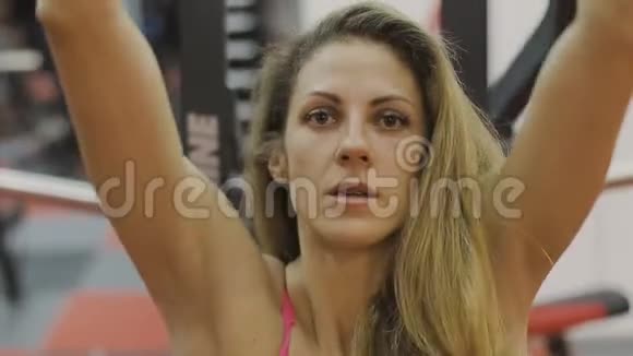 非常漂亮的女教练在健身俱乐部的健身机上训练视频的预览图