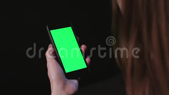 女人手里拿着绿色屏幕的手机视频的预览图