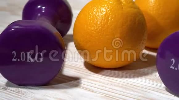 木制背景上的橘子果汁和哑铃视频的预览图