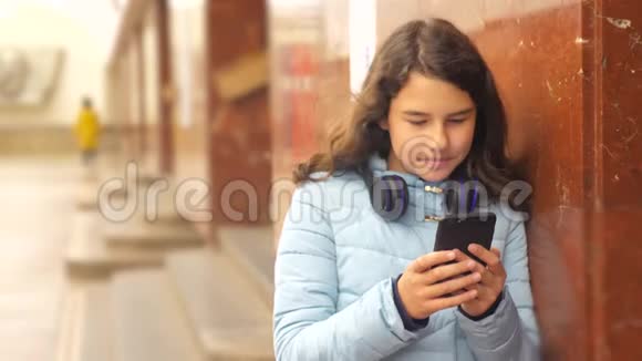 地铁里的少女乘坐地铁的生活方式在地铁里等待火车的到来手持智能手机视频的预览图