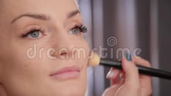 化妆师为美丽的女人做专业的化妆视频的预览图