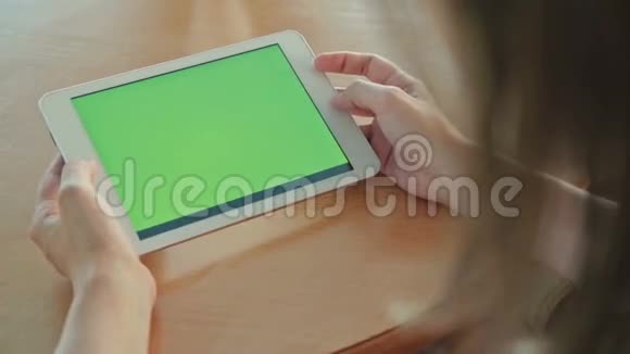 在咖啡馆里看着绿屏平板电脑的女人视频的预览图