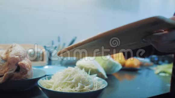 厨房里的女人准备一顿饭的概念厨房生活方式中的女孩用刀切白菜做素食者视频的预览图