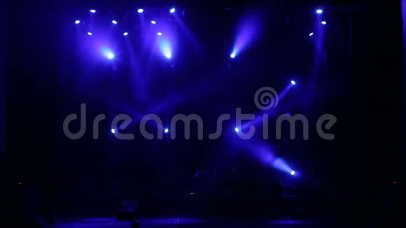 蓝色聚光灯在黑暗中的一个空音乐会舞台上舞台灯光视频的预览图