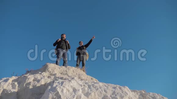 两个人游客徒步探险登山者爬山慢动作视频徒步旅行者登上顶峰赢得胜利视频的预览图