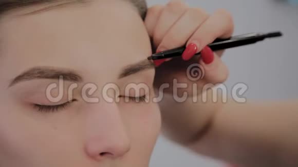 化妆师将专业化妆应用于一个美丽的年轻女孩化妆新概念视频的预览图