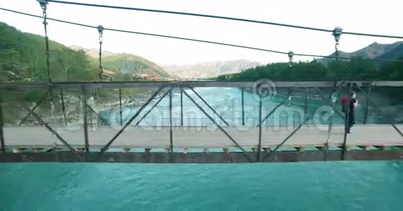 空中飞行越过青年游客穿过吊桥视频的预览图