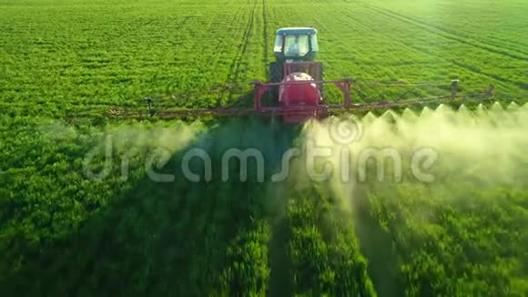 农用拖拉机在绿地上耕田和喷洒的空中视野视频的预览图