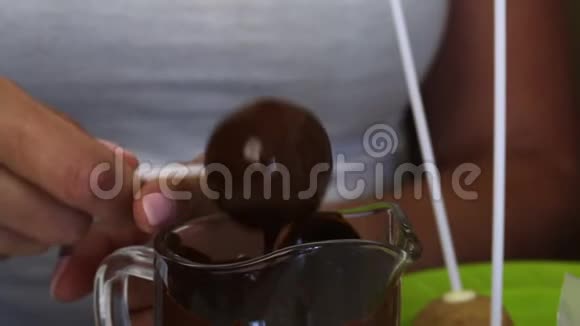 一个女人在黑巧克力中摇动蛋糕在球上均匀分配巧克力视频的预览图