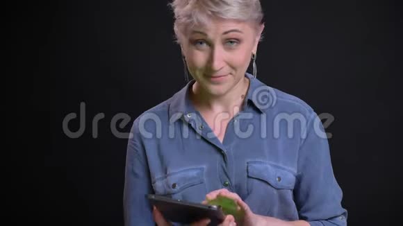 用平板电脑拍摄有魅力的白种人女性的特写肖像并用绿色屏幕拍摄微笑视频的预览图